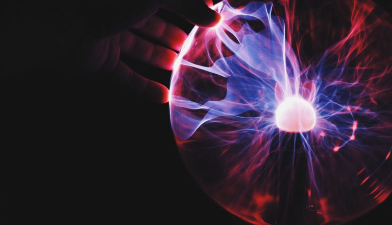 Hand touching tesla ball