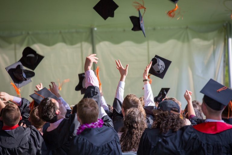 Students throwing the graduation cap into the air